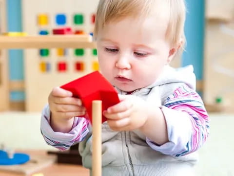 a baby holding a red book