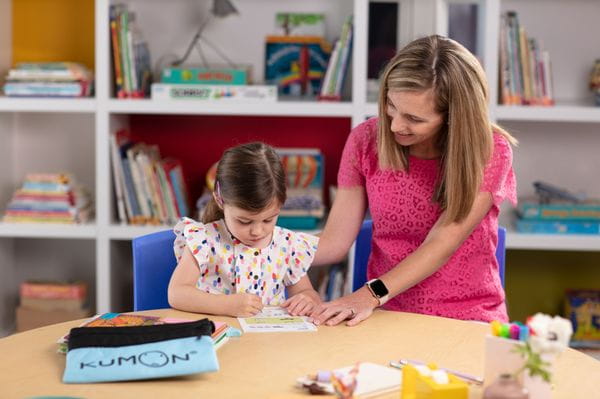 a person and a child looking at a book