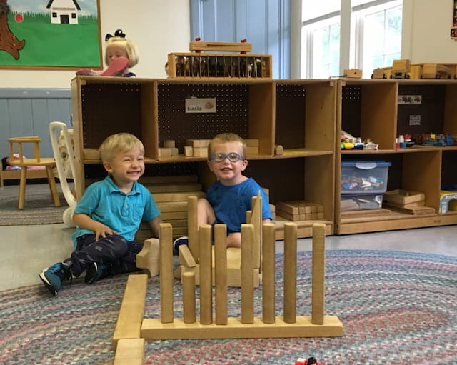 two boys sitting on a wooden structure