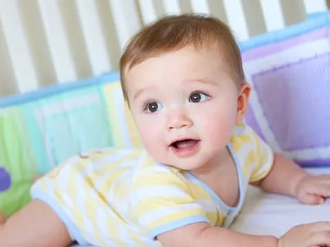 a baby lying on a bed