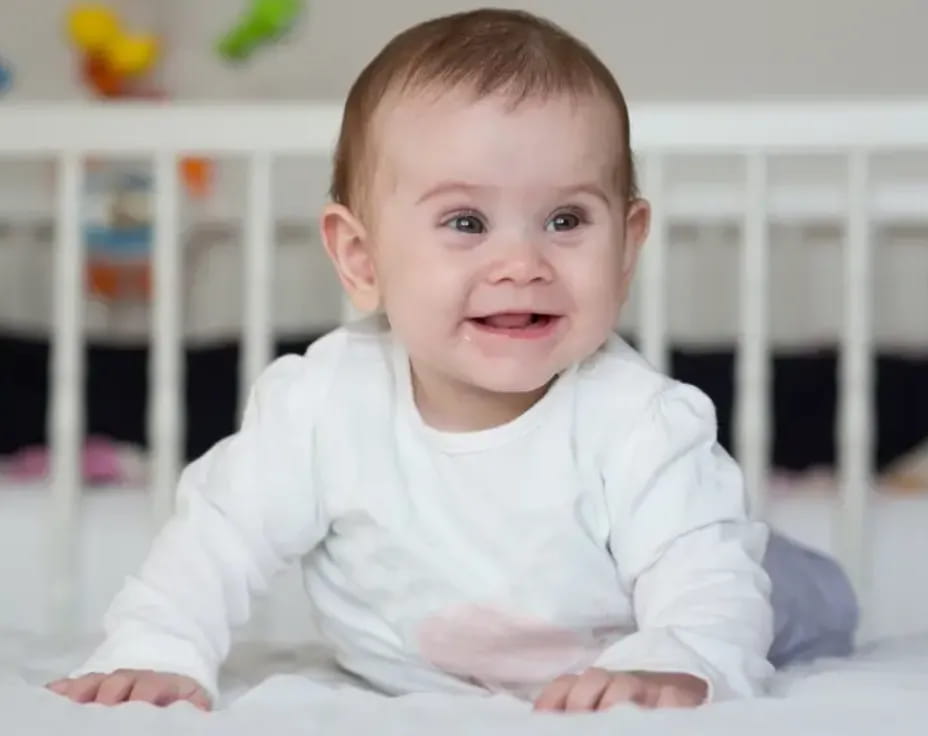 a baby lying on a bed