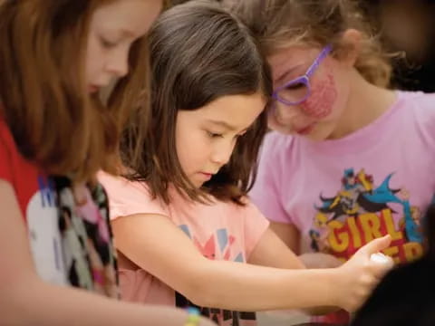 a group of girls looking at a book