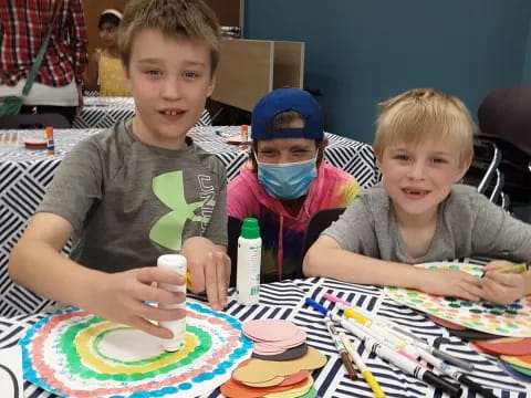 a group of boys sitting at a table with colorful plates