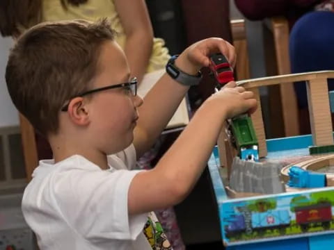 a young boy using a red tool