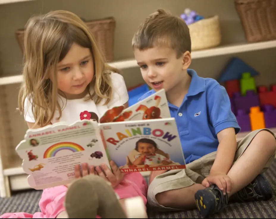 a couple of children reading a book