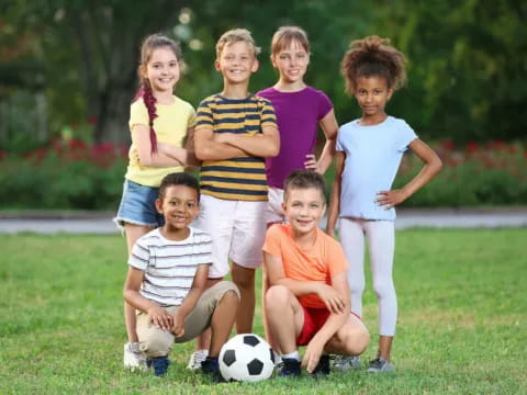 a group of kids posing for a picture with a football ball