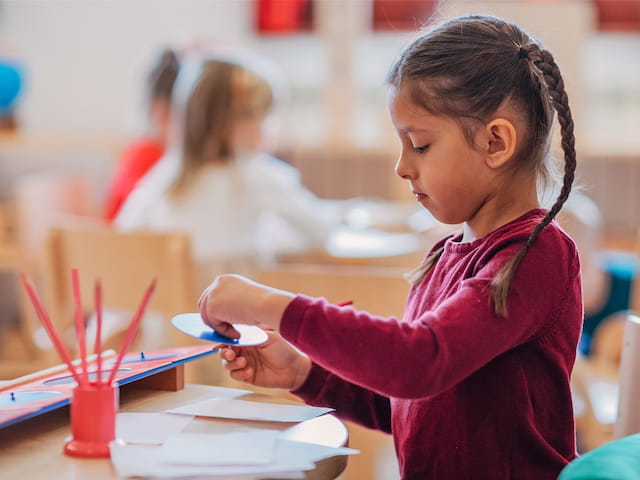 a young girl writing on a book