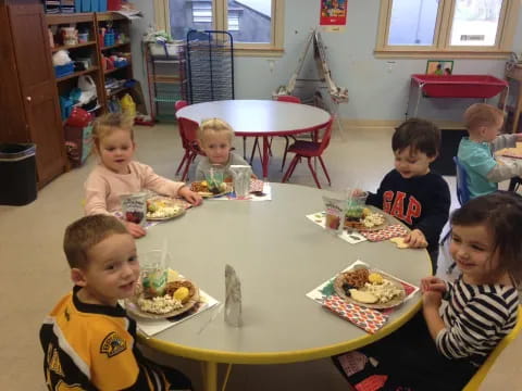 a group of kids eating at a table
