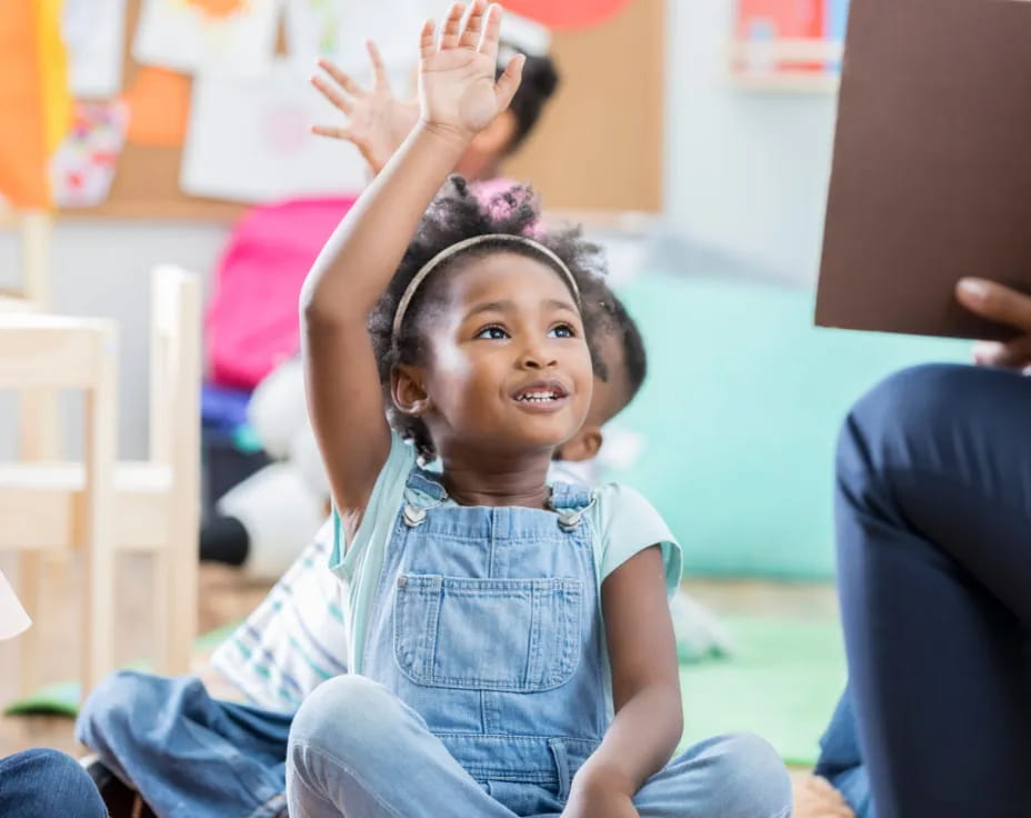 a young girl raising her hands