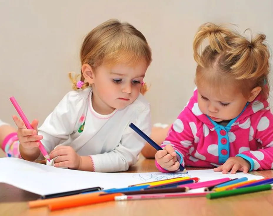 a couple of young girls writing on paper