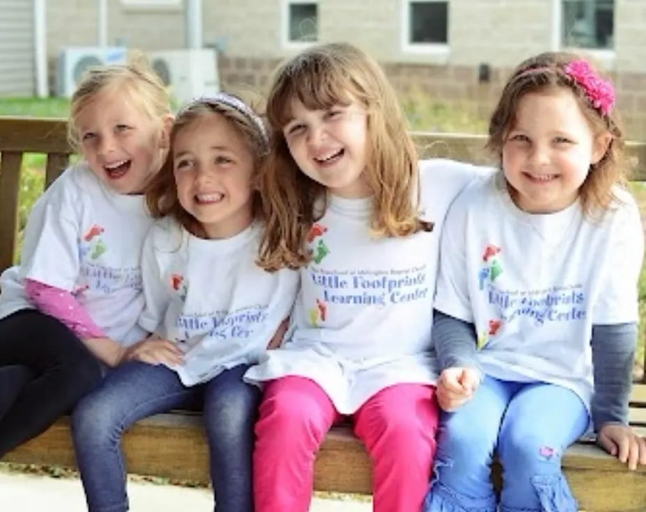 a group of girls sitting on a bench