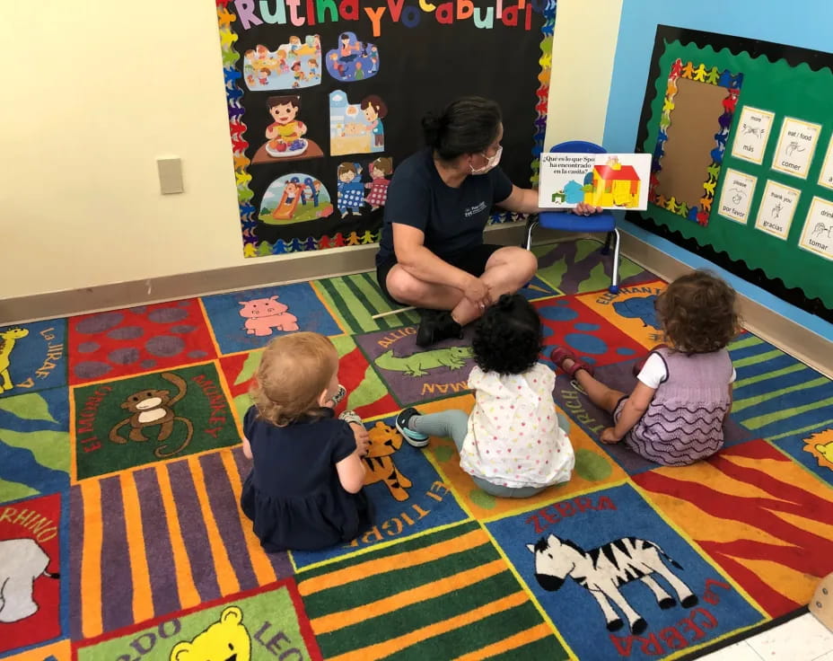 a person and several children sitting on the floor