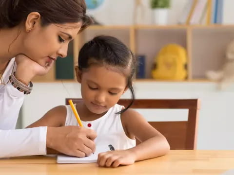 a person and a child writing on a book