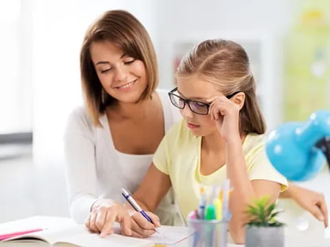 a woman and a girl looking at a paper