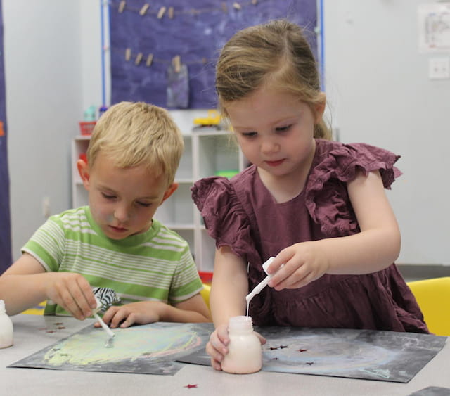 a couple of children painting