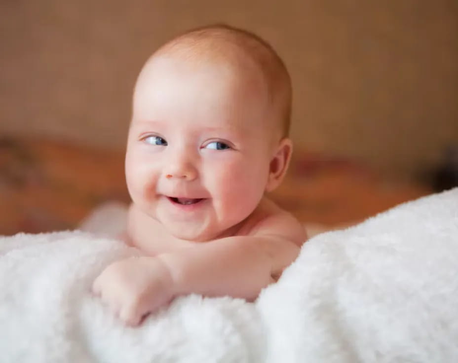 a baby lying on a blanket