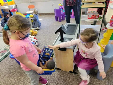 a few young girls playing with toys