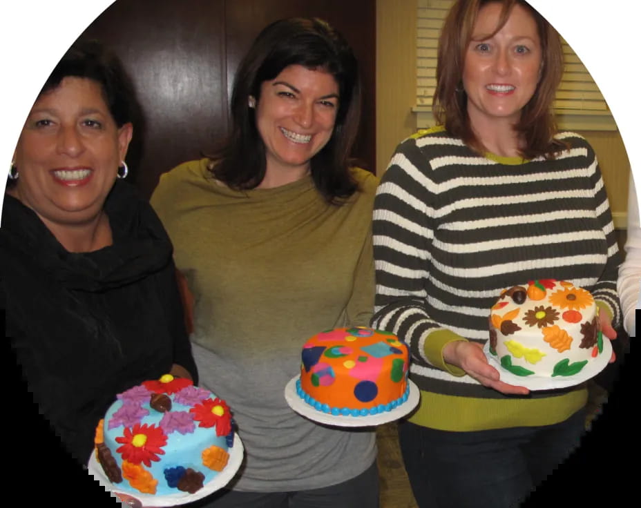 a group of women holding cakes