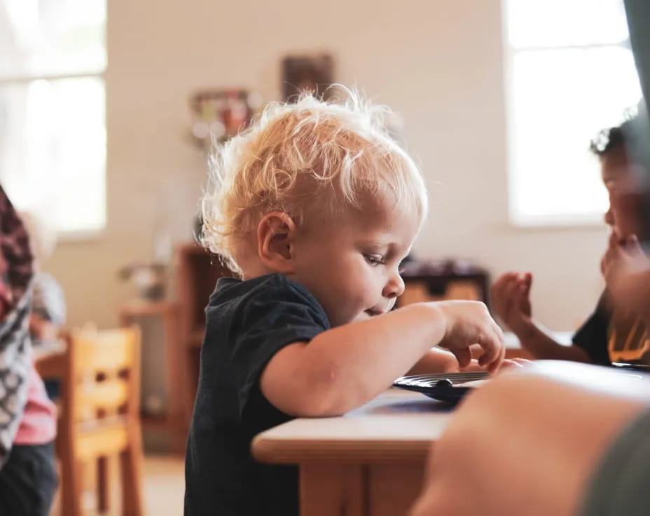a young boy playing with a tablet