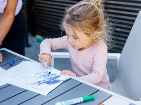 a young girl drawing on a paper