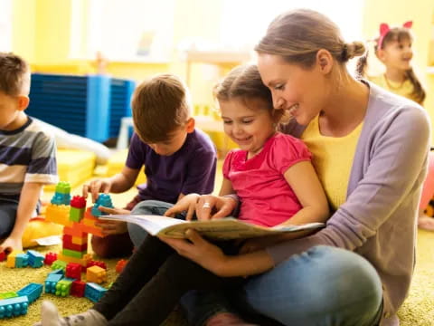 a person reading a book to children