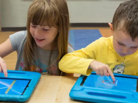 a boy and girl looking at a tablet