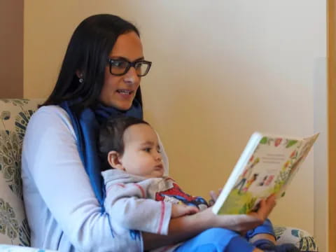 a person reading a book to a baby