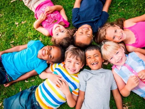 a group of children lying on the ground smiling for the camera