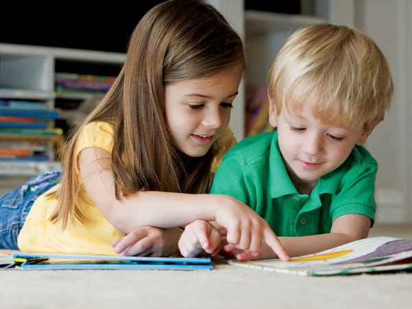 a boy and girl looking at a book