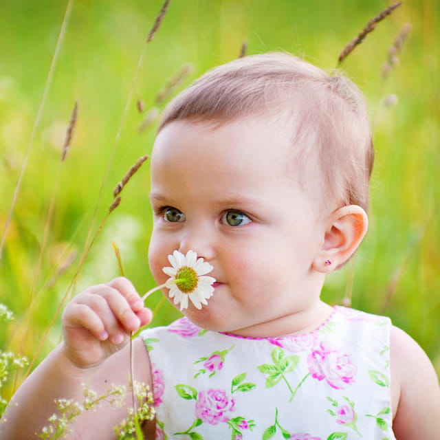 a baby holding a flower