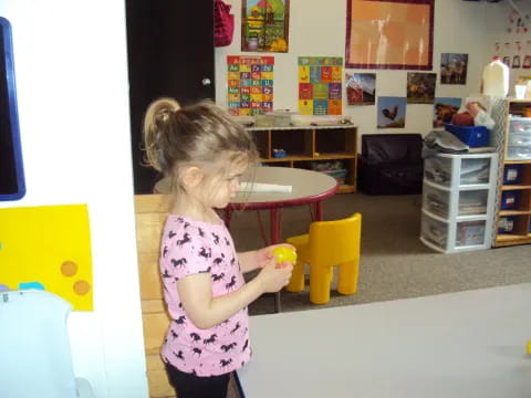 a little girl holding a toy