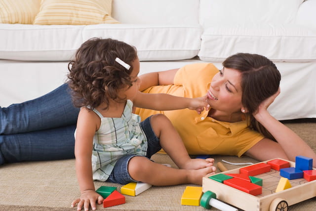 a person and a child playing with toys on the floor