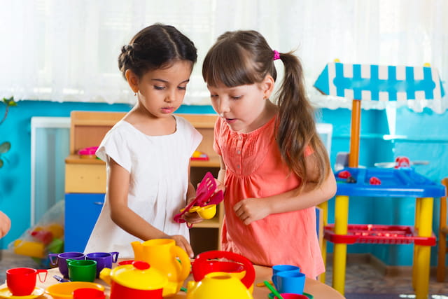 a couple of young girls playing with colorful cups