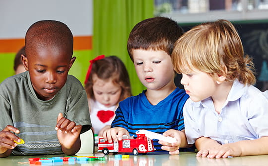 a group of children playing with a toy train