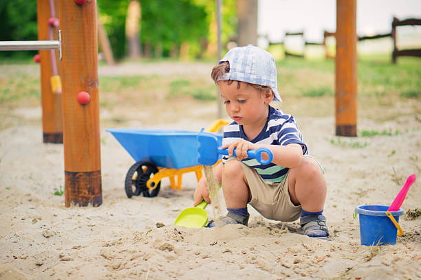 a baby playing in sand