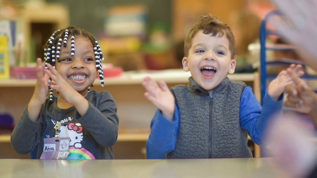 a couple of children holding a stick