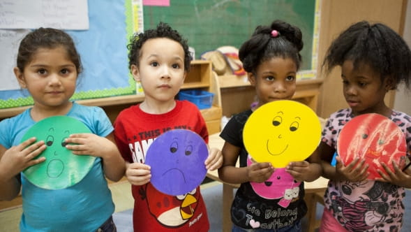a group of children holding up yellow and red toys