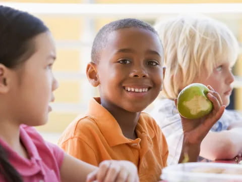 a group of children eating a fruit