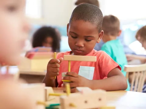 a young boy holding a pencil