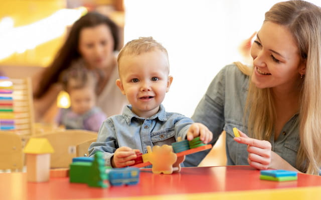 a person and a baby playing with toys