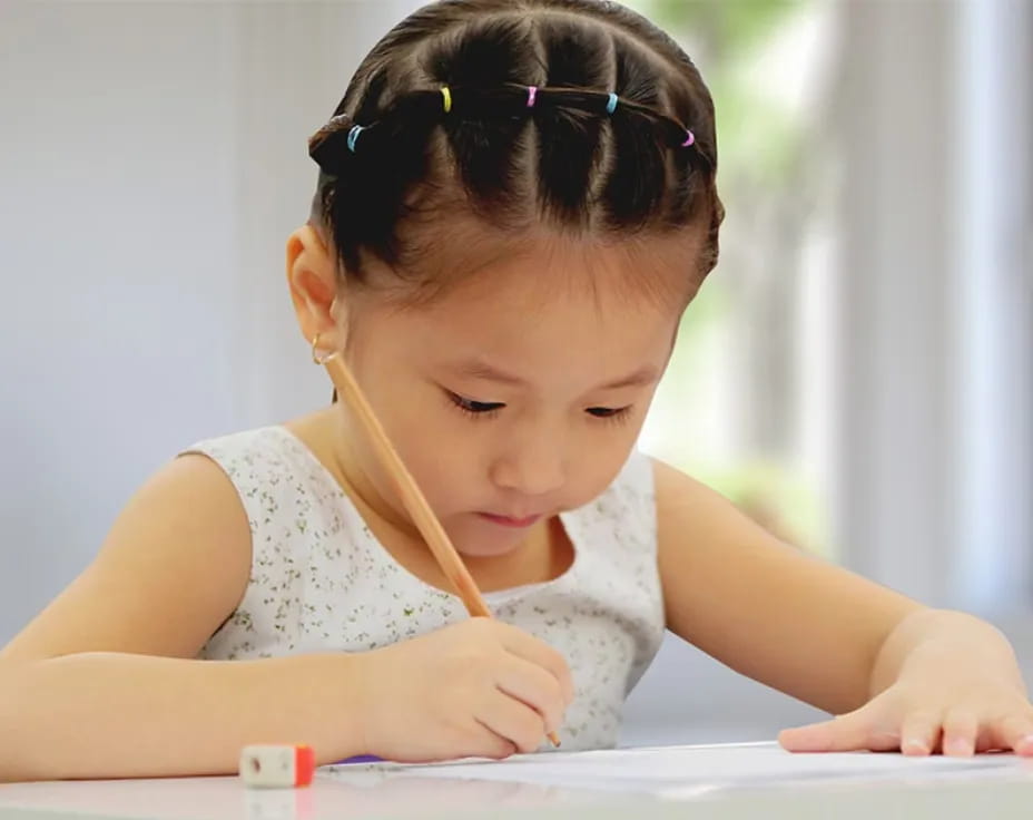 a young girl writing on a book