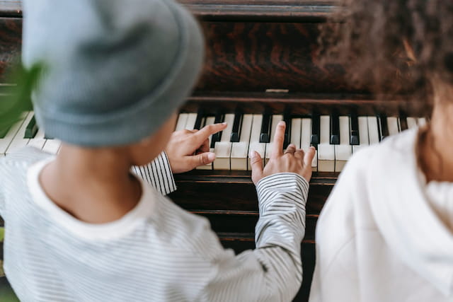 a couple of people playing a piano