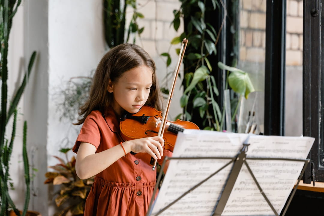 a young girl holding a violin