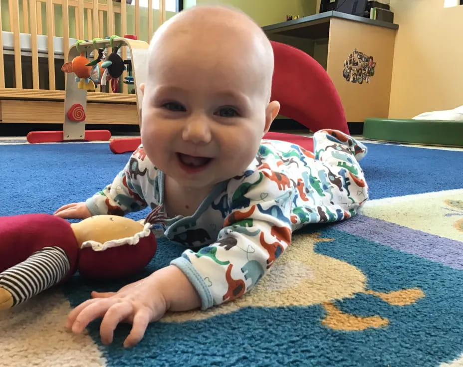 a baby sitting on a rug