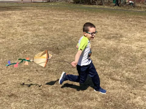 a boy running with a kite