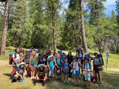 a group of people posing for a photo in the woods