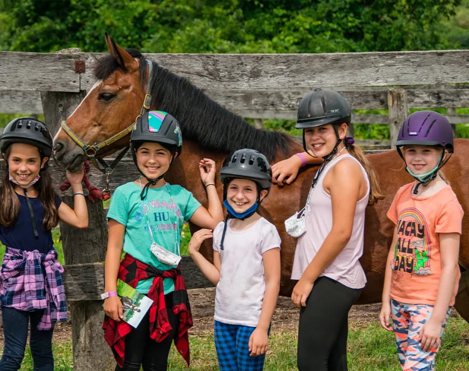 a group of children posing with a horse