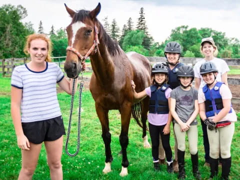a group of people standing next to a horse