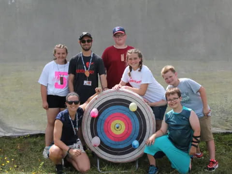 a group of people posing for a photo with a large wheel