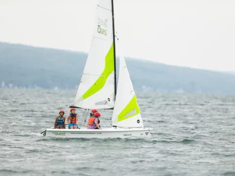 a group of people on a sailboat in the water